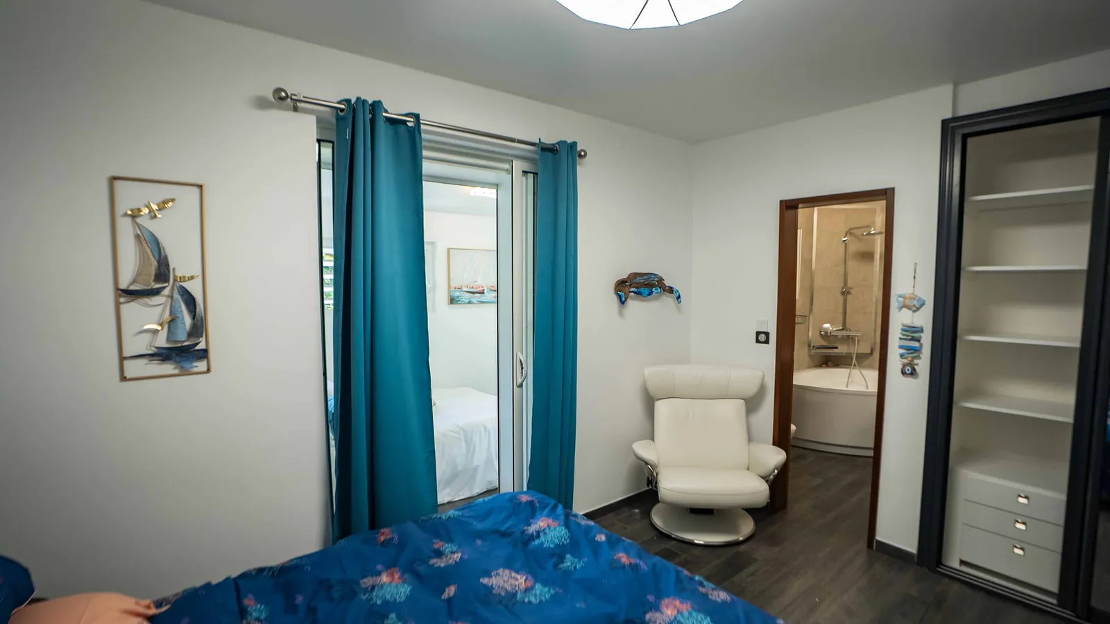 Chambre Sea World — fauteuil de cuir blanc, armoire et porte de la salle de bain