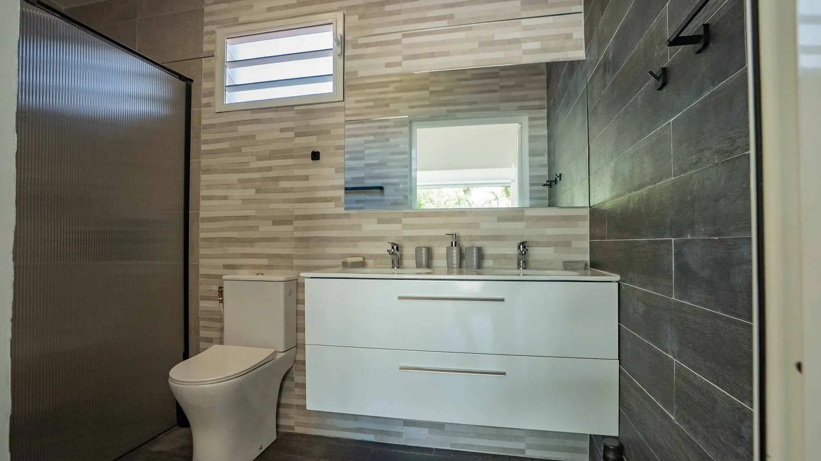Chambre Sport — salle de bain, double vasque et paroi de douche cannelée