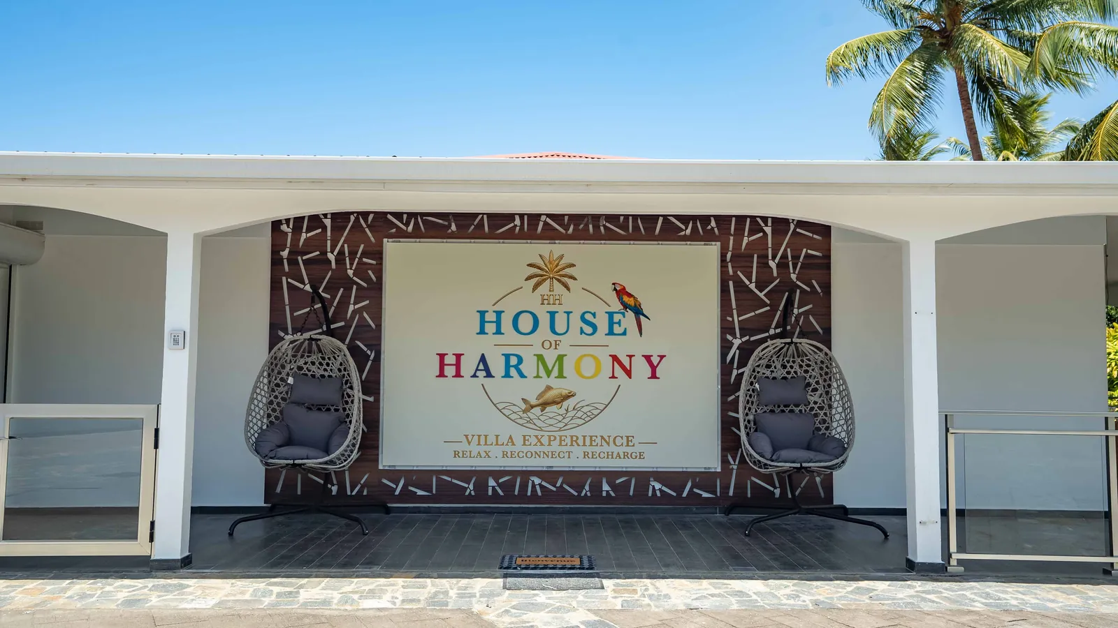 Le porche d'entrée de House of Harmony, l'enseigne et les 2 fauteuils suspendus